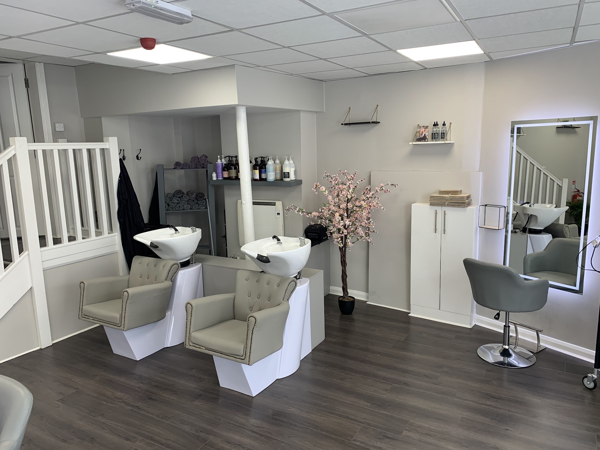 The salon floor: two backwash basins, a styling chair and a lit mirror