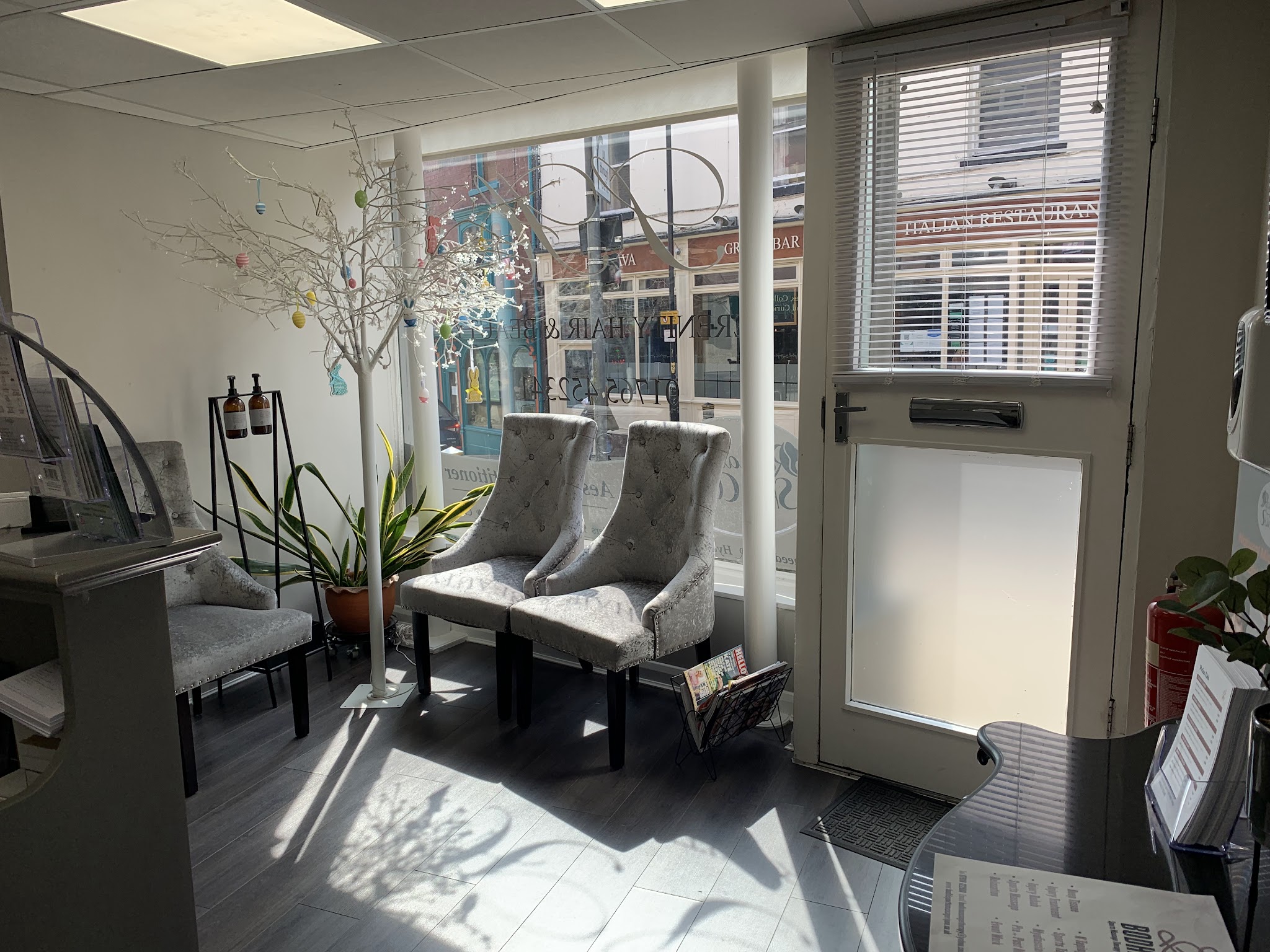 Reception and waiting area with velvet chairs by the shop window